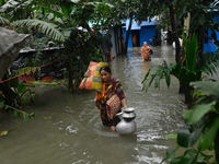 Local residents shift to temporary shelter homes as floodwater rises in their homes in Feni, Chittagong, Bangladesh, on August 23, 2024. (