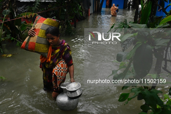 Local residents shift to temporary shelter homes as floodwater rises in their homes in Feni, Chittagong, Bangladesh, on August 23, 2024. 