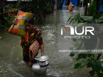 Local residents shift to temporary shelter homes as floodwater rises in their homes in Feni, Chittagong, Bangladesh, on August 23, 2024. (