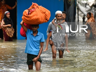 People wade through floodwater in Feni, Chittagong, Bangladesh, on August 23, 2024. (