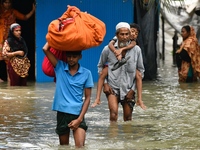 People wade through floodwater in Feni, Chittagong, Bangladesh, on August 23, 2024. (