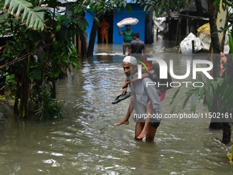 People wade through floodwater in Feni, Chittagong, Bangladesh, on August 23, 2024. (