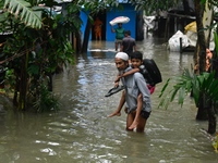 People wade through floodwater in Feni, Chittagong, Bangladesh, on August 23, 2024. (