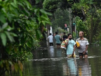 People wade through floodwater in Feni, Chittagong, Bangladesh, on August 23, 2024. (