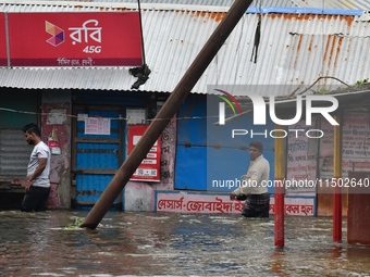 People wade through floodwater in Feni, Chittagong, Bangladesh, on August 23, 2024. (