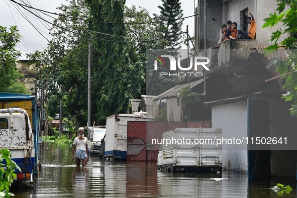 People wade through floodwater in Feni, Chittagong, Bangladesh, on August 23, 2024. 