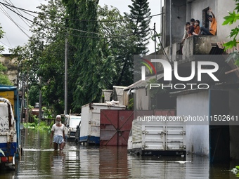 People wade through floodwater in Feni, Chittagong, Bangladesh, on August 23, 2024. (