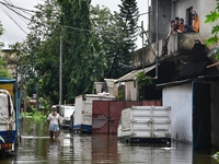 People wade through floodwater in Feni, Chittagong, Bangladesh, on August 23, 2024. (