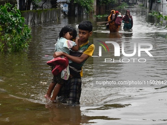 People wade through floodwater in Feni, Chittagong, Bangladesh, on August 23, 2024. (