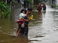 People wade through floodwater in Feni, Chittagong, Bangladesh, on August 23, 2024. (