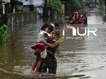 People wade through floodwater in Feni, Chittagong, Bangladesh, on August 23, 2024. (