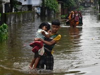 People wade through floodwater in Feni, Chittagong, Bangladesh, on August 23, 2024. (