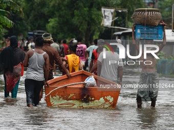 People wade through floodwater in Feni, Chittagong, Bangladesh, on August 23, 2024. (