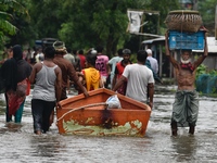 People wade through floodwater in Feni, Chittagong, Bangladesh, on August 23, 2024. (