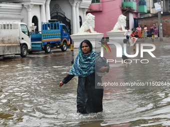 People wade through floodwater in Feni, Chittagong, Bangladesh, on August 23, 2024. (