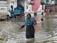 People wade through floodwater in Feni, Chittagong, Bangladesh, on August 23, 2024. (