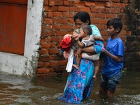 People wade through floodwater in Feni, Chittagong, Bangladesh, on August 23, 2024. (