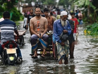 People wade through floodwater in Feni, Chittagong, Bangladesh, on August 23, 2024. (