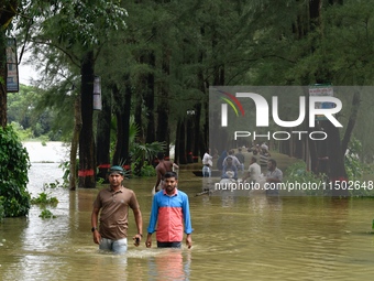 People wade through floodwater in Feni, Chittagong, Bangladesh, on August 23, 2024. (