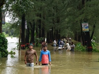 People wade through floodwater in Feni, Chittagong, Bangladesh, on August 23, 2024. (