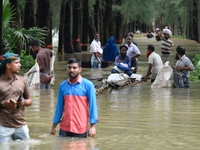 People wade through floodwater in Feni, Chittagong, Bangladesh, on August 23, 2024. (