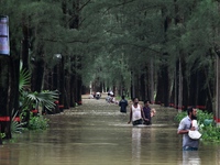 People wade through floodwater in Feni, Chittagong, Bangladesh, on August 23, 2024. (