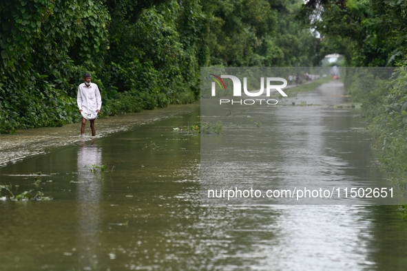 People wade through floodwater in Feni, Chittagong, Bangladesh, on August 23, 2024. 