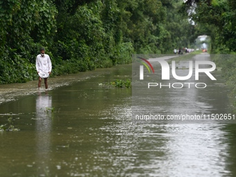 People wade through floodwater in Feni, Chittagong, Bangladesh, on August 23, 2024. (