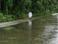 People wade through floodwater in Feni, Chittagong, Bangladesh, on August 23, 2024. (