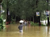 People wade through floodwater in Feni, Chittagong, Bangladesh, on August 23, 2024. (