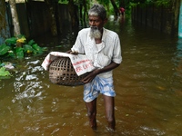 People wade through floodwater in Feni, Chittagong, Bangladesh, on August 23, 2024. (