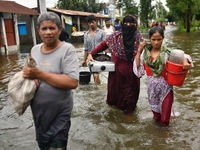 People wade through floodwater in Feni, Chittagong, Bangladesh, on August 23, 2024. (