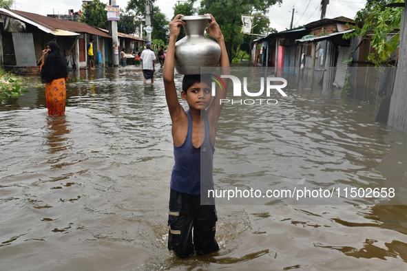 People wade through floodwater in Feni, Chittagong, Bangladesh, on August 23, 2024. 