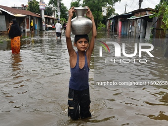 People wade through floodwater in Feni, Chittagong, Bangladesh, on August 23, 2024. (