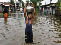 People wade through floodwater in Feni, Chittagong, Bangladesh, on August 23, 2024. (