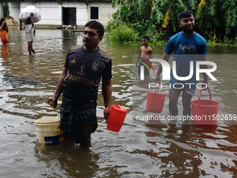 People wade through floodwater in Feni, Chittagong, Bangladesh, on August 23, 2024. (