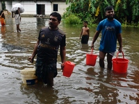 People wade through floodwater in Feni, Chittagong, Bangladesh, on August 23, 2024. (