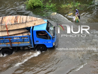 People wade through floodwater in Feni, Chittagong, Bangladesh, on August 23, 2024. (