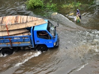 People wade through floodwater in Feni, Chittagong, Bangladesh, on August 23, 2024. (