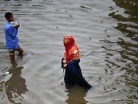 People wade through floodwater in Feni, Chittagong, Bangladesh, on August 23, 2024. (