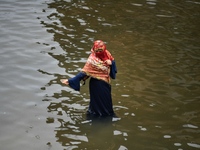 People wade through floodwater in Feni, Chittagong, Bangladesh, on August 23, 2024. (