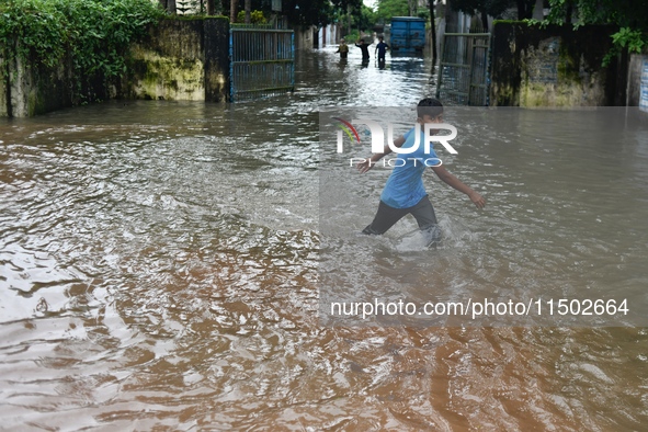 People wade through floodwater in Feni, Chittagong, Bangladesh, on August 23, 2024. 