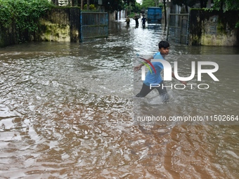 People wade through floodwater in Feni, Chittagong, Bangladesh, on August 23, 2024. (