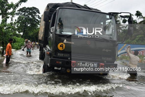 People wade through floodwater in Feni, Chittagong, Bangladesh, on August 23, 2024. 