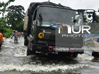 People wade through floodwater in Feni, Chittagong, Bangladesh, on August 23, 2024. (