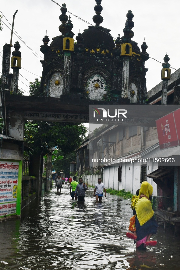 People wade through floodwater in Feni, Chittagong, Bangladesh, on August 23, 2024. 