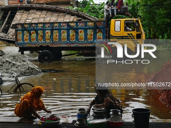 Flood-affected people take shelter in an under-construction building in Feni, Chittagong, Bangladesh, on August 23, 2024. (