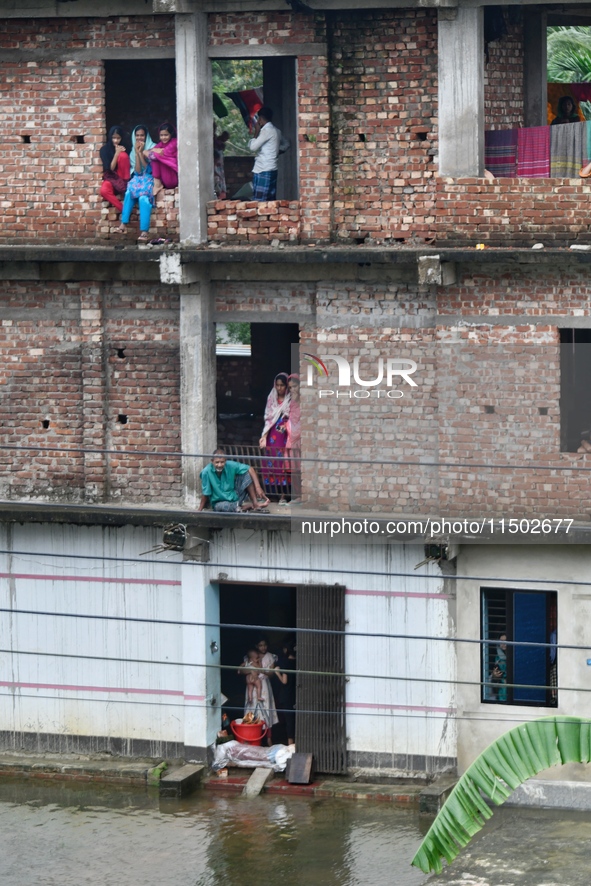 Flood-affected people take shelter in an under-construction building in Feni, Chittagong, Bangladesh, on August 23, 2024. 