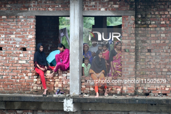 Flood-affected people take shelter in an under-construction building in Feni, Chittagong, Bangladesh, on August 23, 2024. 