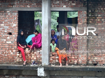 Flood-affected people take shelter in an under-construction building in Feni, Chittagong, Bangladesh, on August 23, 2024. (